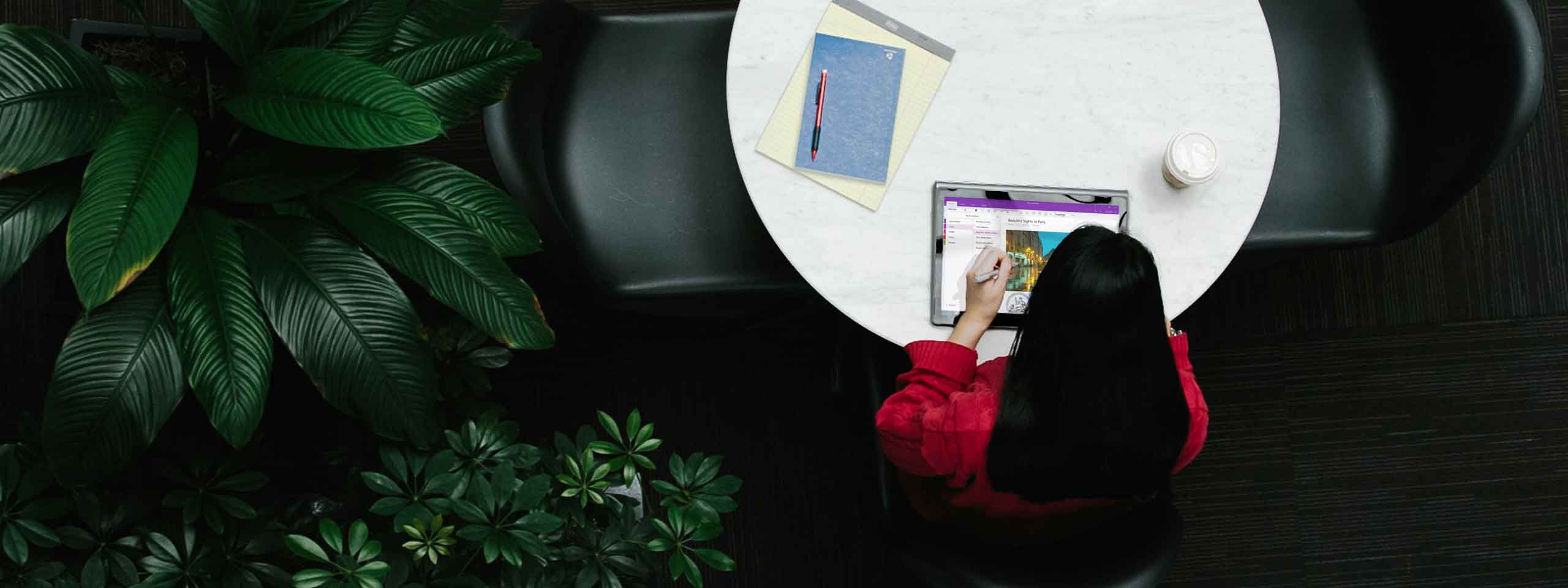 Photo of a person using OneNote on a tablet for work